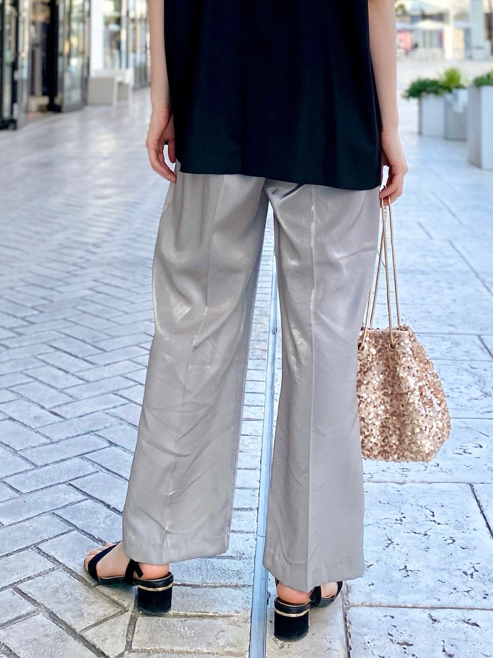 ブラック系のベスト、ホワイト系のTシャツ/カットソー、シルバー系のスラックスを着用したレディースの春コーディネートの4枚目の写真