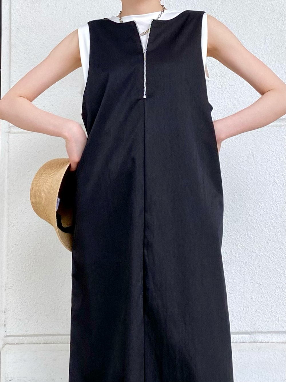 ブラック系のワンピース、ホワイト系のTシャツ/カットソー、ブラック系のサンダルを着用したレディースの春コーディネートの3枚目の写真