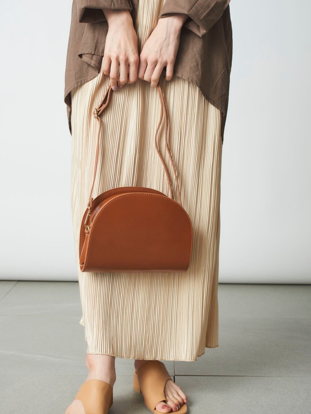 ベージュ系のシャツ/ブラウス、ホワイト系のスカート、ブラウン系のショルダーバッグを着用したレディースの春コーディネートの3枚目の写真