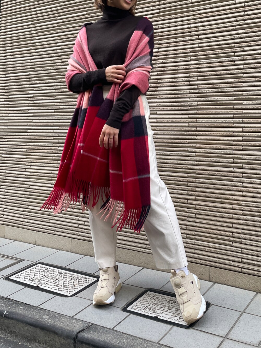レッド系のマフラーを着用したレディースの冬コーディネートの2枚目の写真