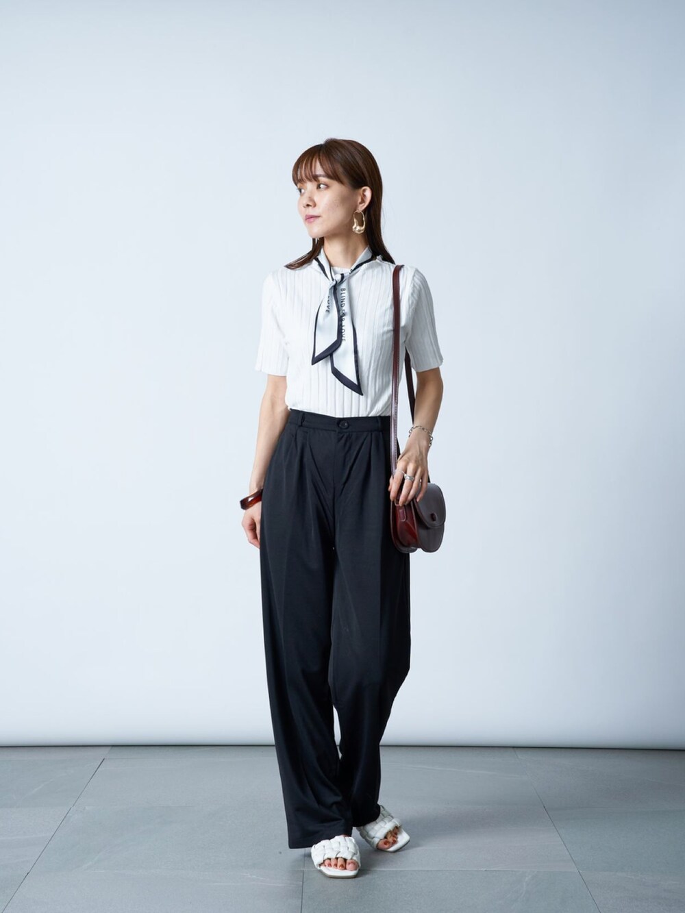 ブラック系のその他パンツ、ブラウン系のショルダーバッグ、ホワイト系のTシャツ/カットソーを着用したレディースの夏コーディネートの2枚目の写真