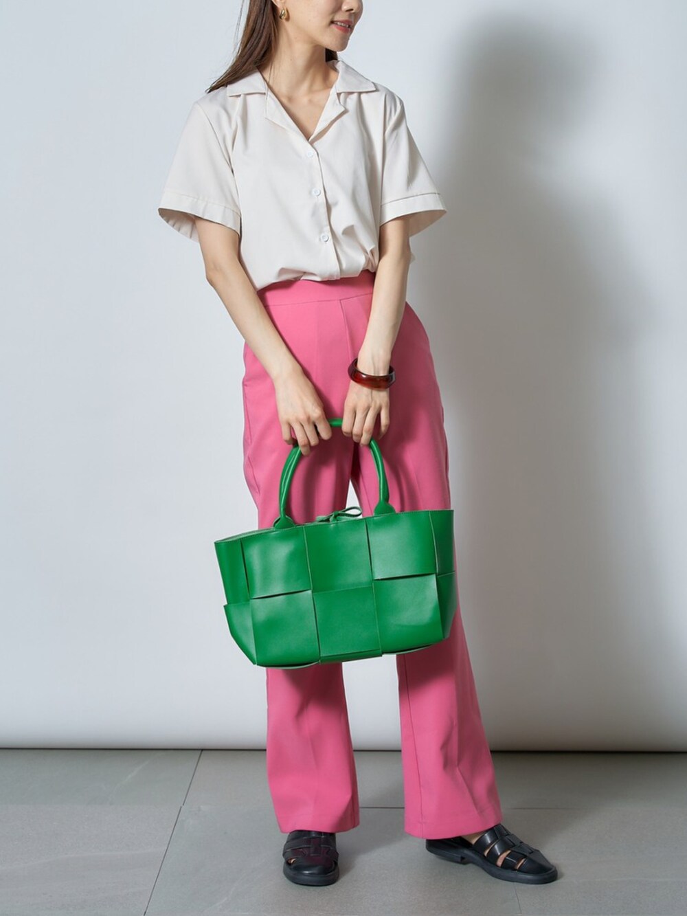 ホワイト系のシャツ/ブラウス、グリーン系のトートバッグ、ブラック系のサンダルを着用したレディースの夏コーディネートの2枚目の写真