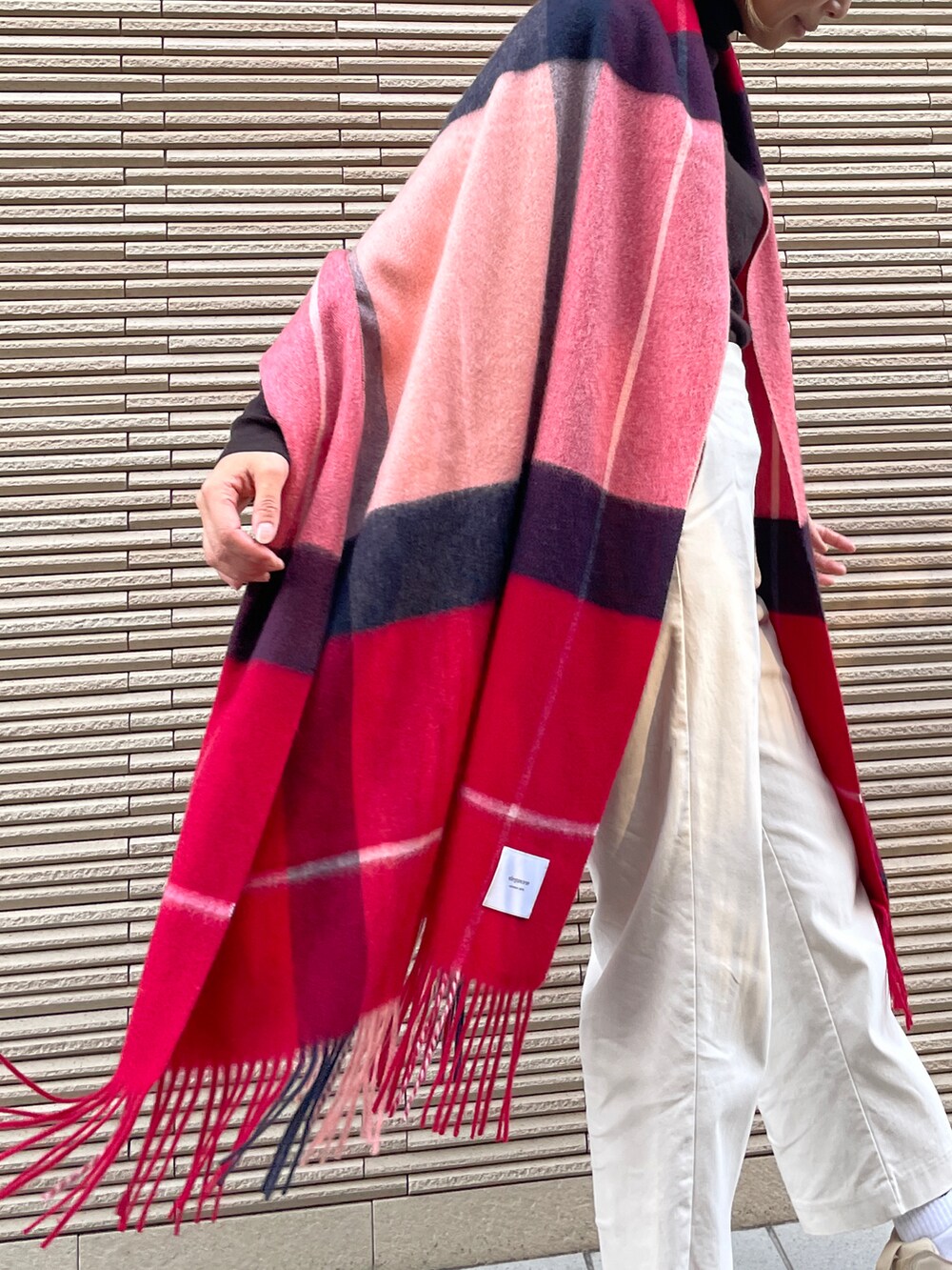 レッド系のマフラーを着用したレディースの冬コーディネートの3枚目の写真