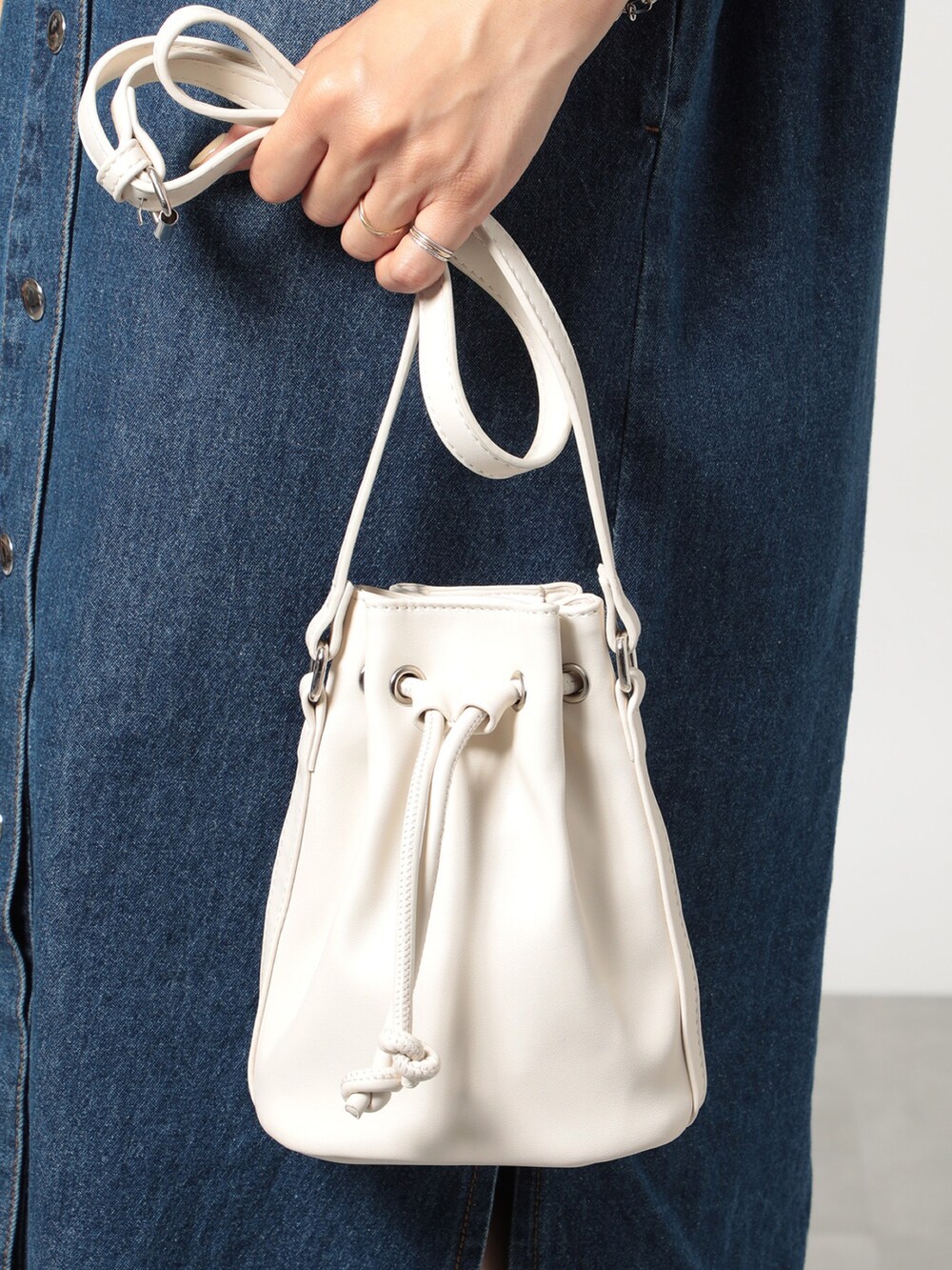 ブルー系のシャツワンピース、ベージュ系のショルダーバッグ、その他のサンダルを着用したレディースの夏コーディネートの2枚目の写真