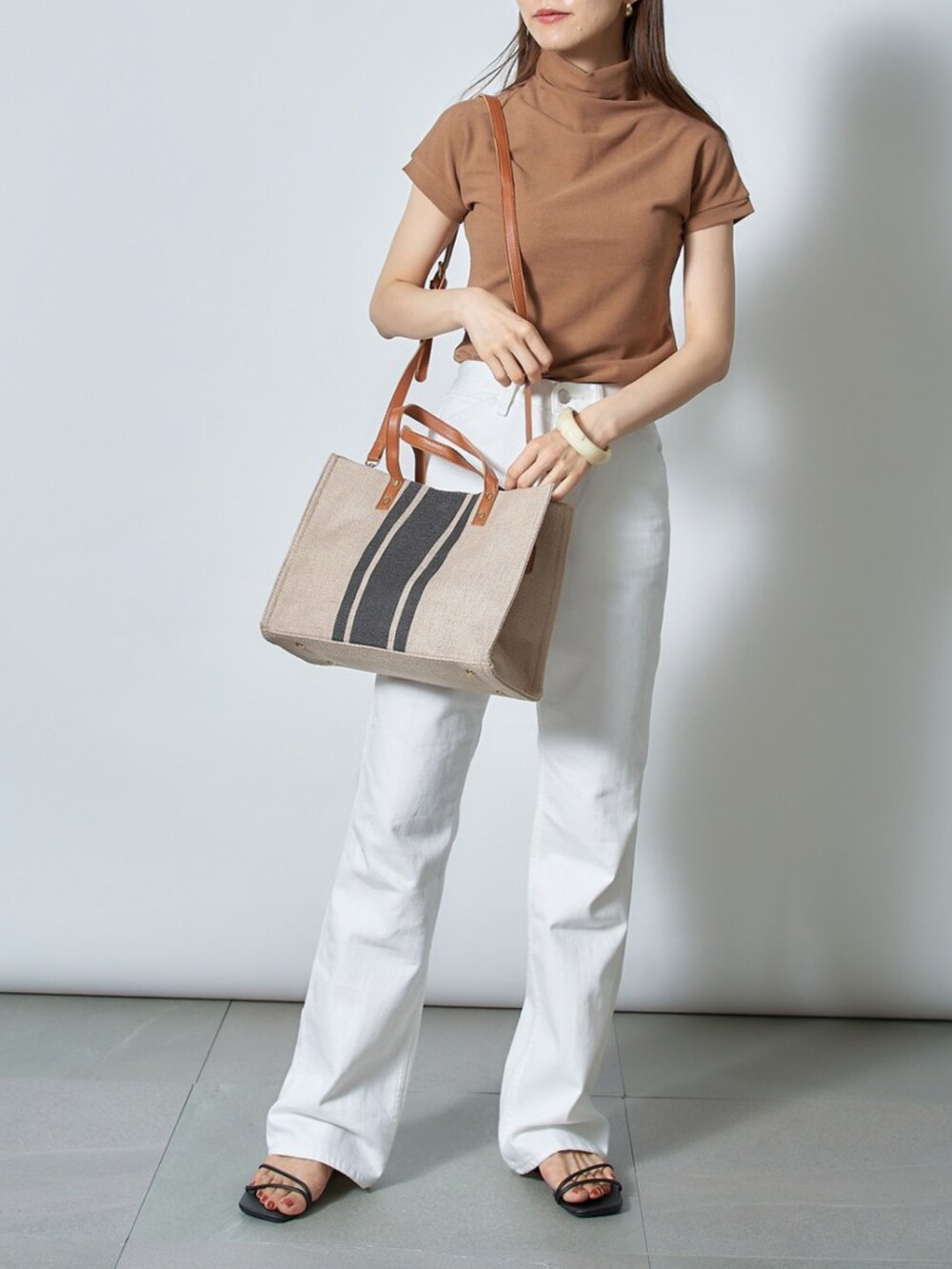 ホワイト系のTシャツ/カットソー、ブラック系のサンダル、ブルー系のトートバッグを着用したレディースの夏コーディネートの2枚目の写真