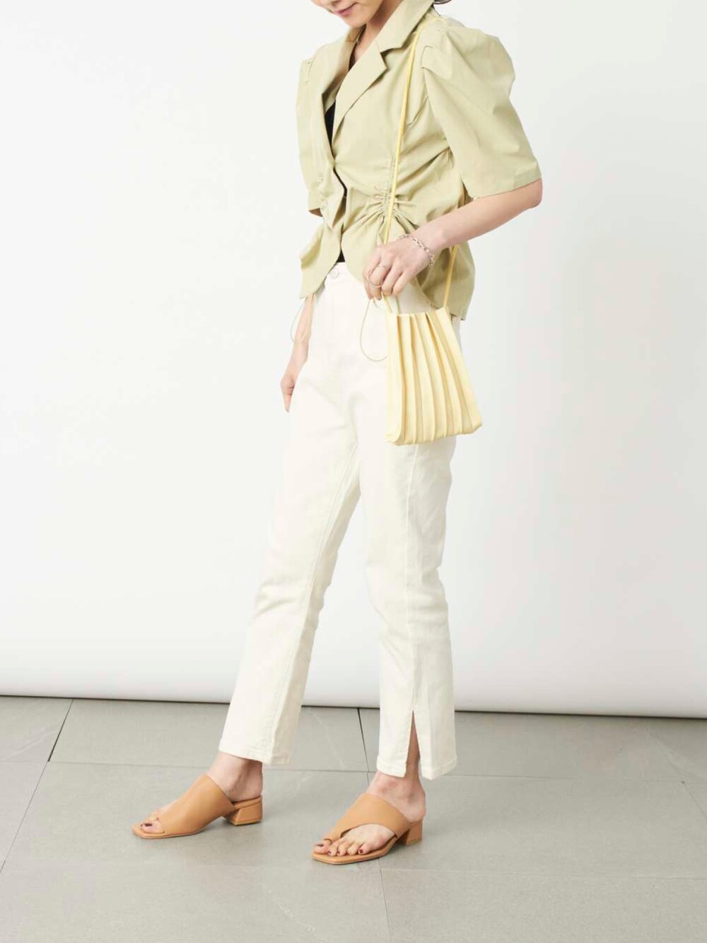 ホワイト系のデニムパンツ、イエロー系のショルダーバッグ、グリーン系のその他アウターを着用したレディースの夏コーディネートの2枚目の写真