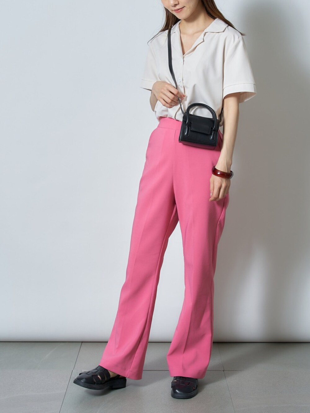 ホワイト系のシャツ/ブラウス、ブラック系のショルダーバッグ、ブラック系のサンダルを着用したレディースの夏コーディネートの2枚目の写真