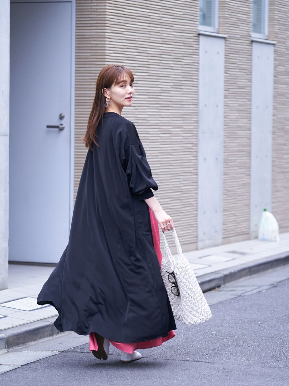 ピンク系のワンピース、ブラック系のワンピース、ベージュ系のバッグを着用したレディースの夏コーディネートの2枚目の写真