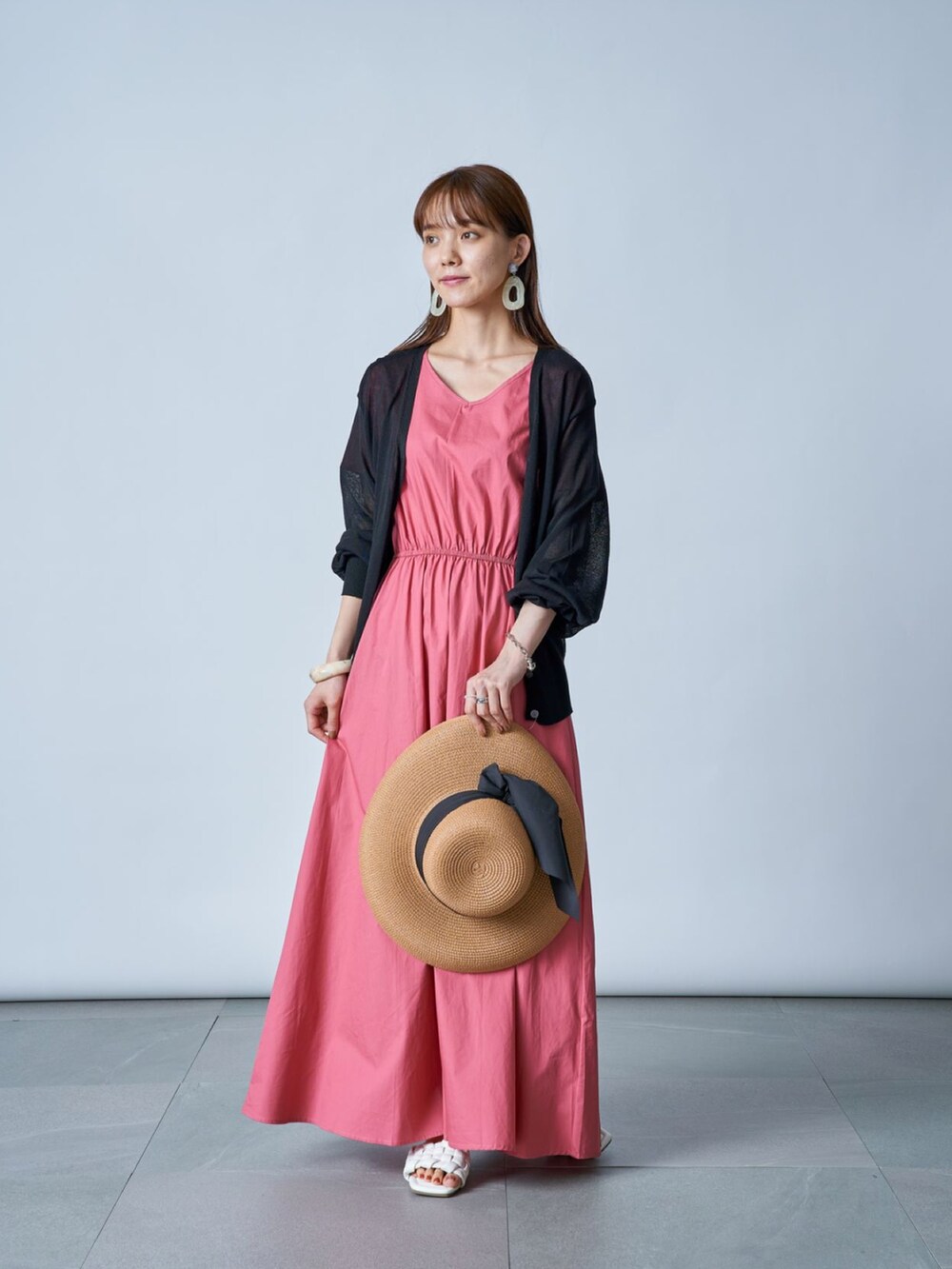 ピンク系のワンピース、ブラック系のカーディガン/ボレロ、ベージュ系のハットを着用したレディースの夏コーディネートの2枚目の写真