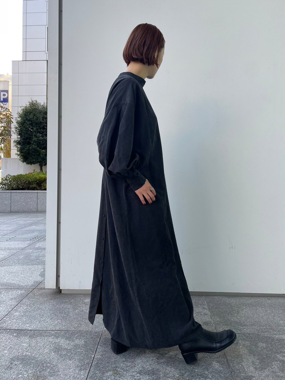 ブラック系のワンピース、シルバー系のトートバッグ、ブラック系のブーツを着用したレディースの冬コーディネートの2枚目の写真