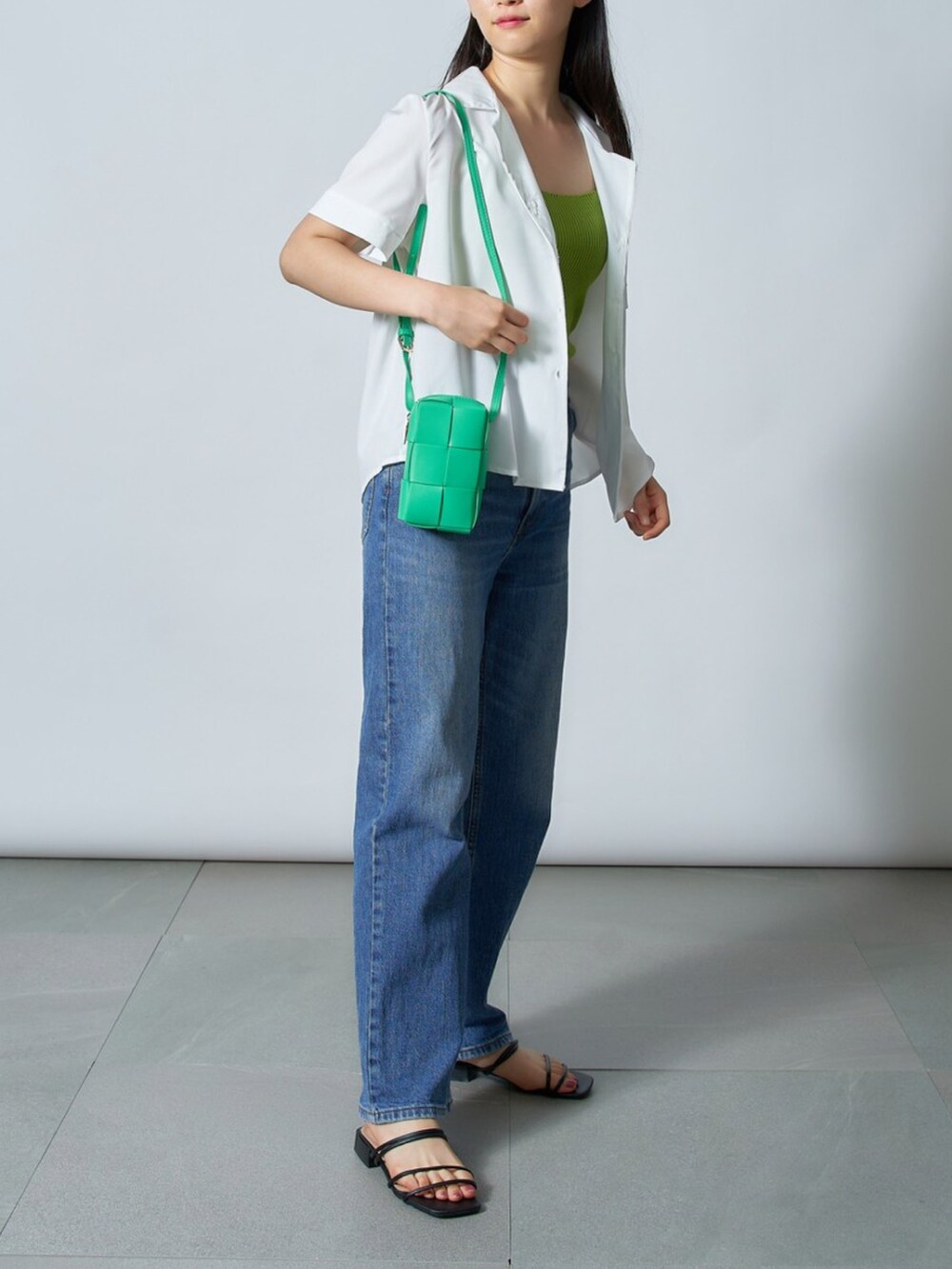 ホワイト系のシャツ/ブラウス、ブラック系のサンダル、グリーン系のショルダーバッグを着用したレディースの夏コーディネートの2枚目の写真