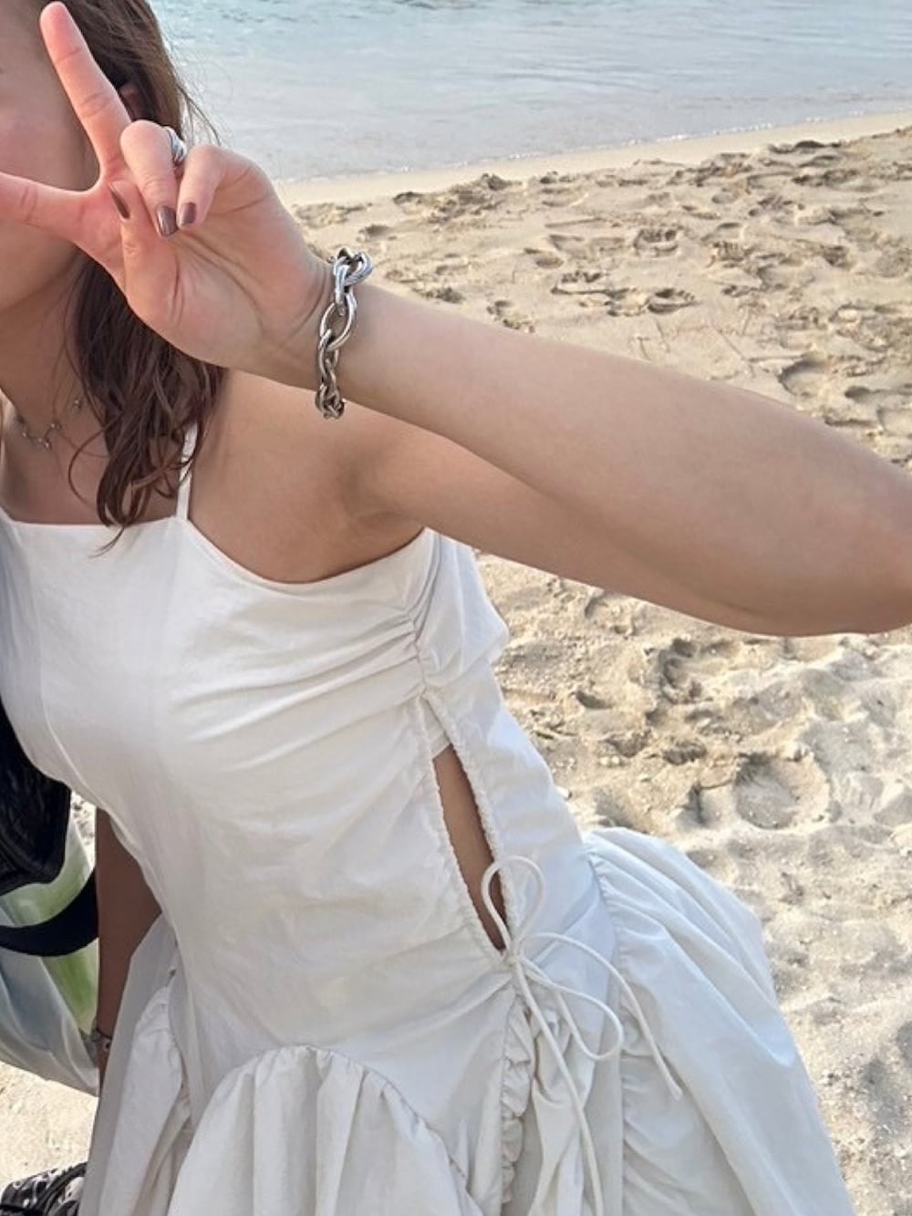 ホワイト系のワンピース、ブラック系のサンダルを着用したレディースの夏コーディネートの2枚目の写真