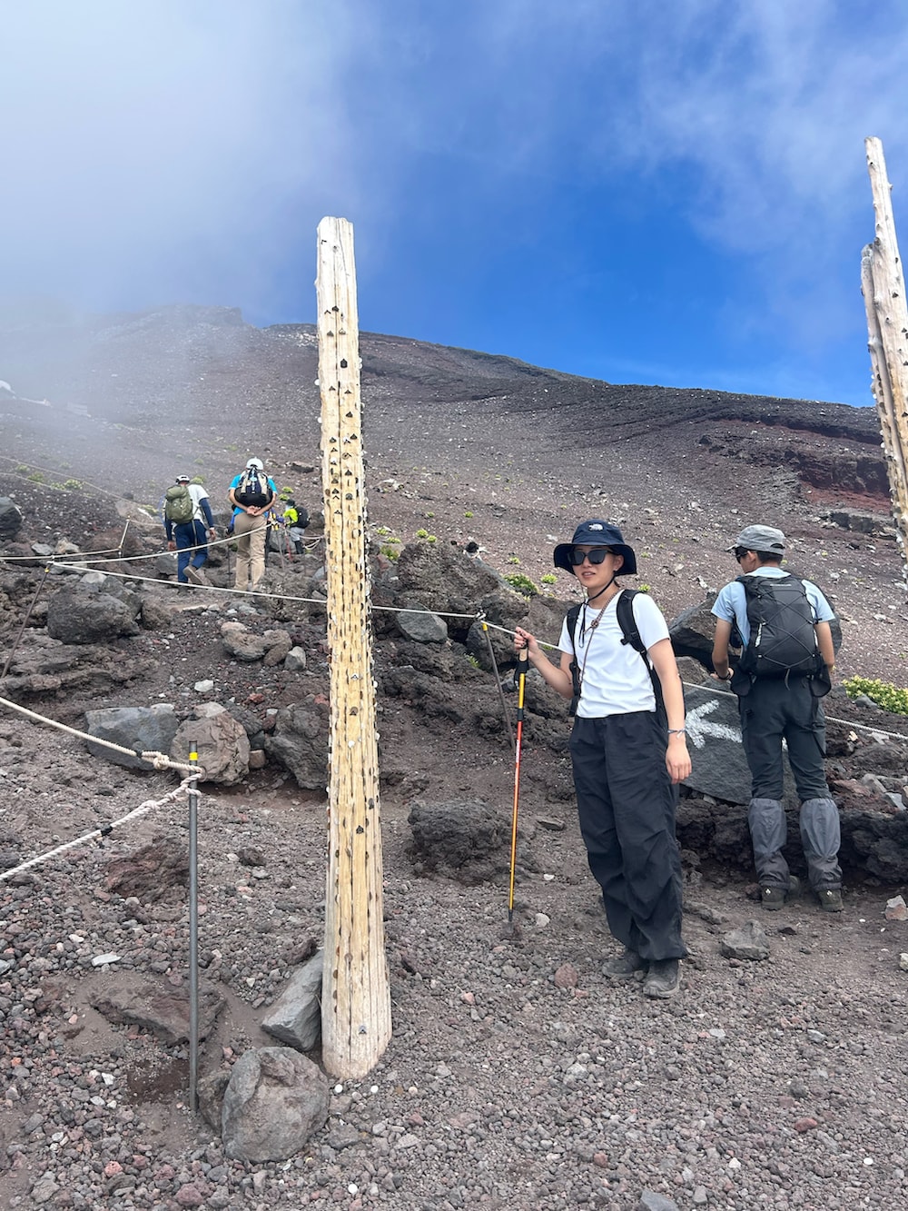 ブラック系のカーゴパンツ、ブラック系のシューズ、ホワイト系のTシャツ/カットソーを着用したレディースの夏コーディネートの2枚目の写真