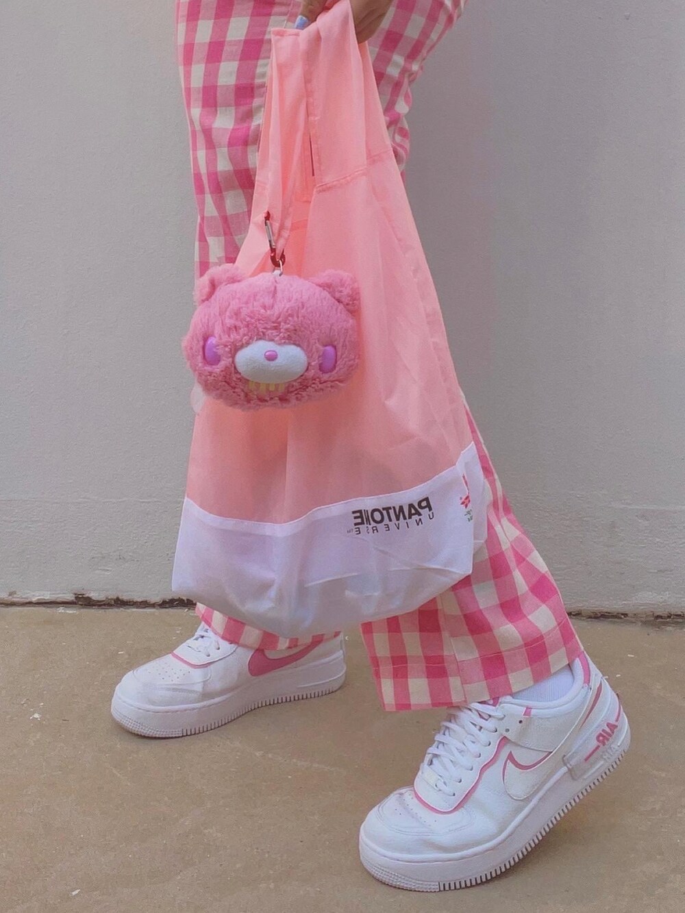 ホワイト系のスニーカー、ピンク系のネックレス、ピンク系のアナログ腕時計を着用したレディースの冬コーディネートの3枚目の写真