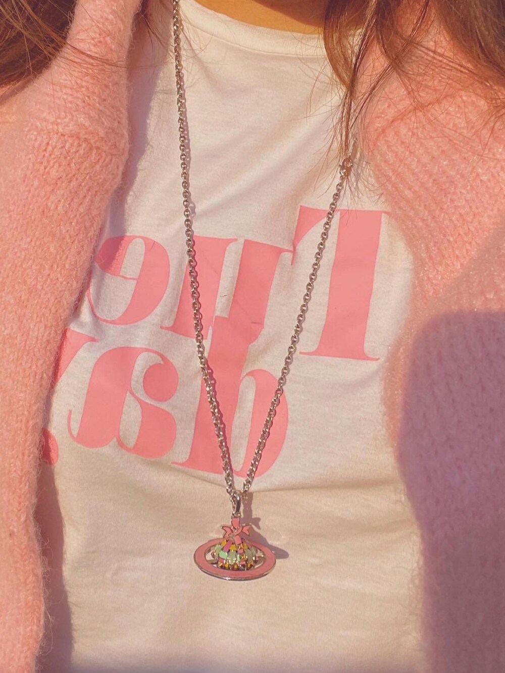 ホワイト系のスニーカー、ピンク系のネックレス、ピンク系のアナログ腕時計を着用したレディースの冬コーディネートの4枚目の写真