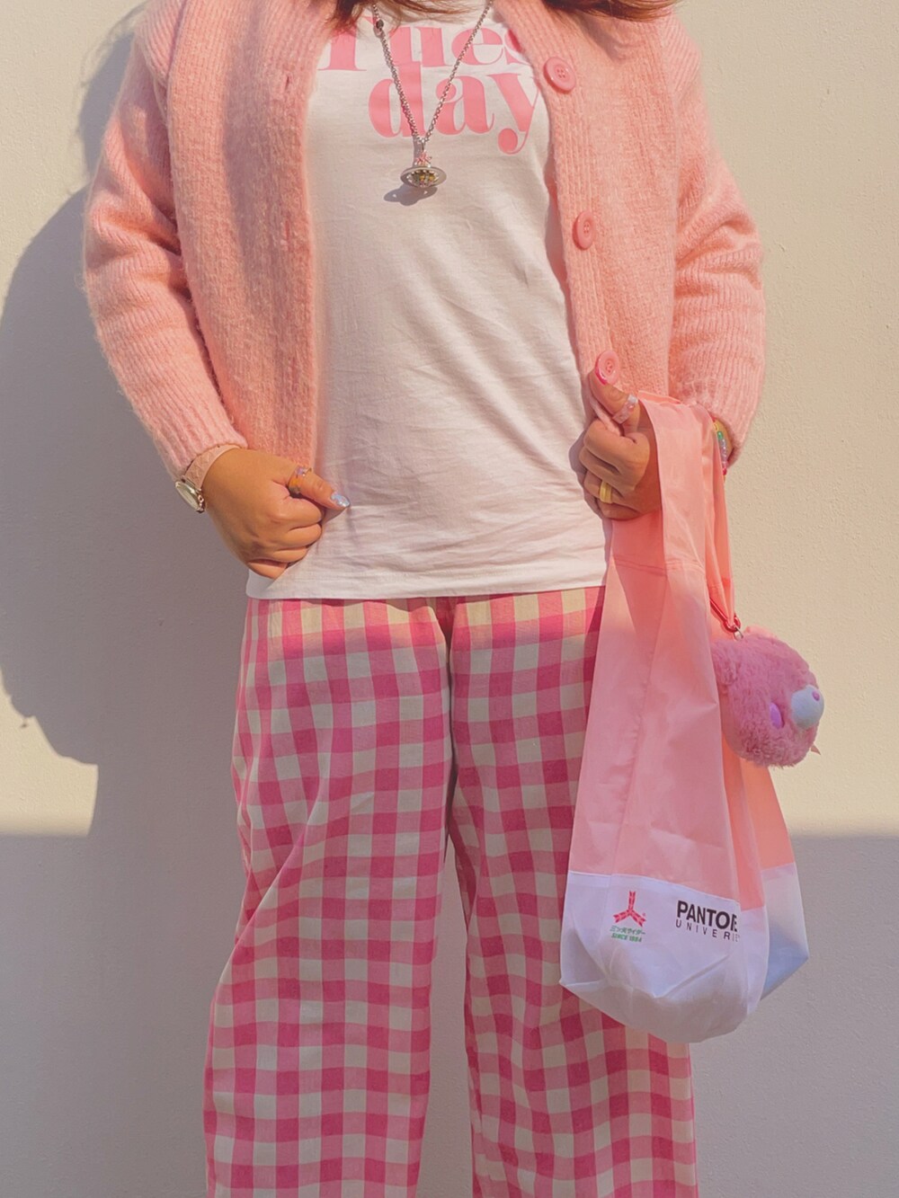 ホワイト系のスニーカー、ピンク系のネックレス、ピンク系のアナログ腕時計を着用したレディースの冬コーディネートの5枚目の写真