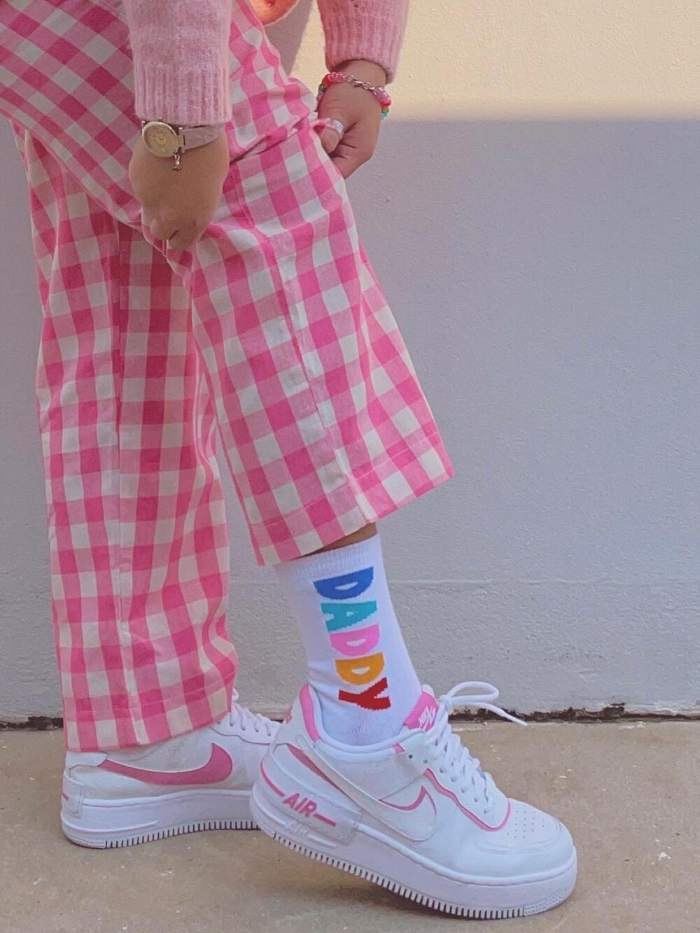 ホワイト系のスニーカー、ピンク系のネックレス、ピンク系のアナログ腕時計を着用したレディースの冬コーディネートの2枚目の写真