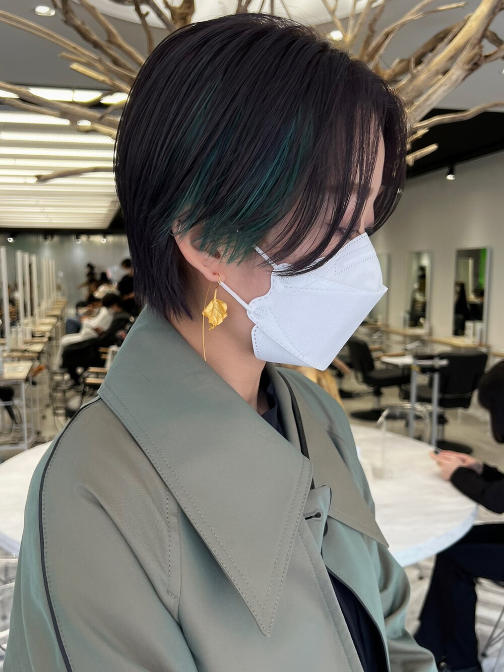 グリーン系のその他パンツ、グリーン系のトレンチコート、ブラック系のブーツを着用したレディースの春コーディネートの2枚目の写真