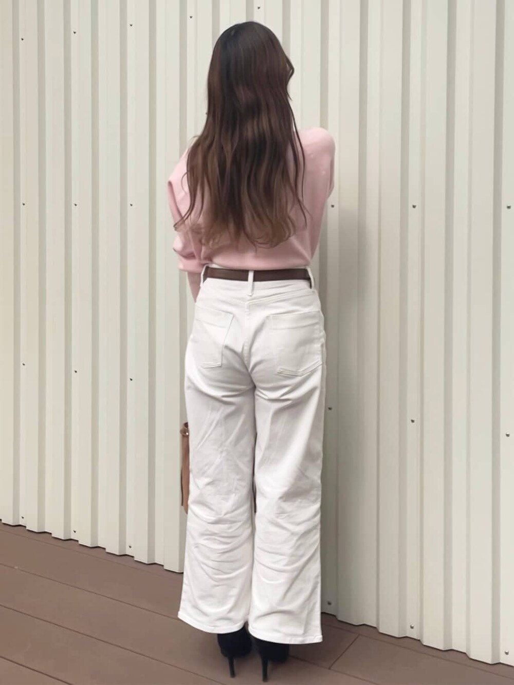 ピンク系のニット/セーター、ホワイト系のデニムパンツ、ブラウン系のトートバッグを着用したレディースの冬コーディネートの4枚目の写真