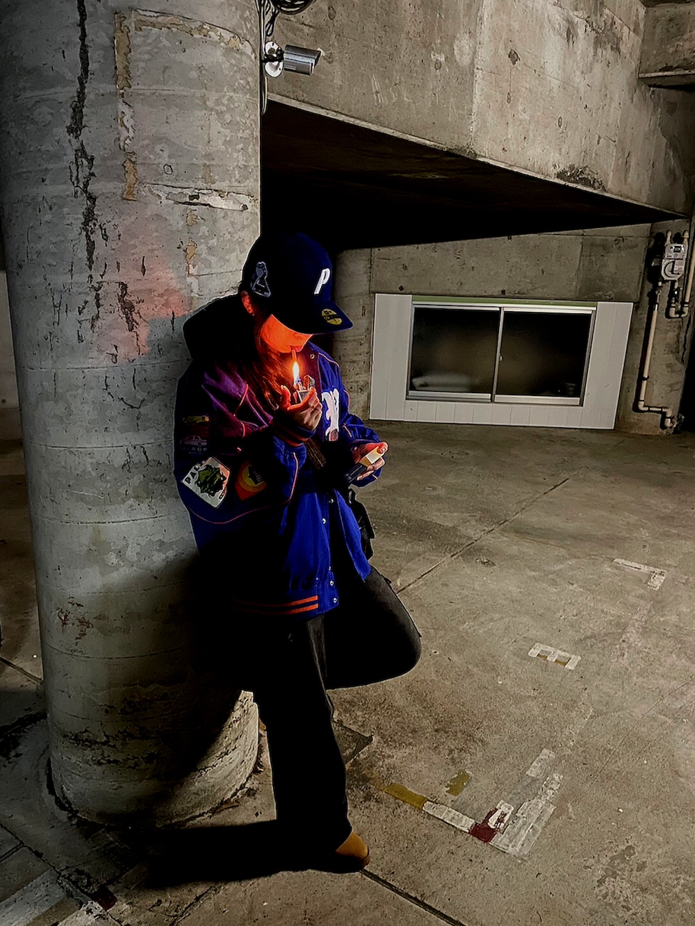 ブルー系のスタジャン、ブラック系のパーカー、ブラック系のショルダーバッグを着用したメンズの冬コーディネートの2枚目の写真