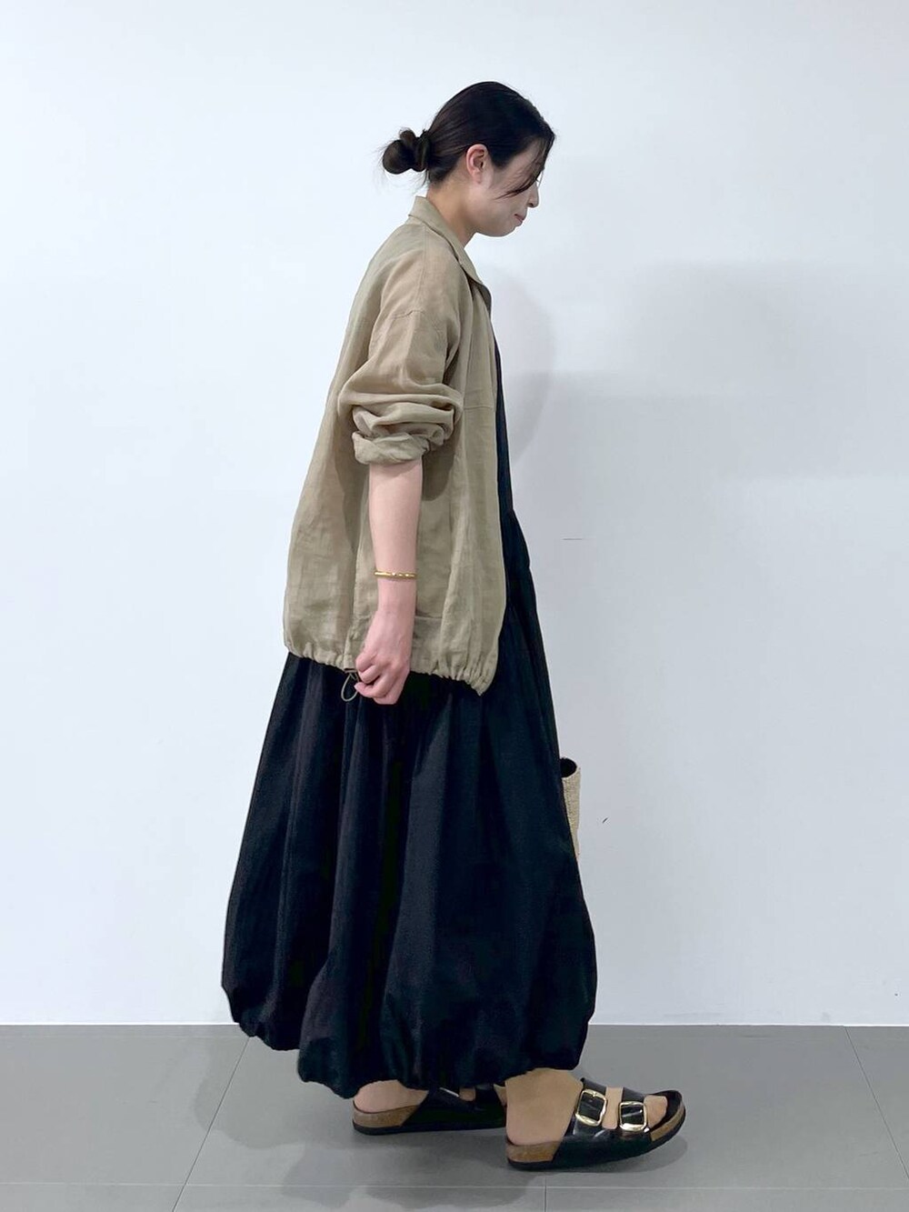 ベージュ系のブルゾン、ブラック系のサンダル、ベージュ系のかごバッグを着用したレディースの春コーディネートの2枚目の写真