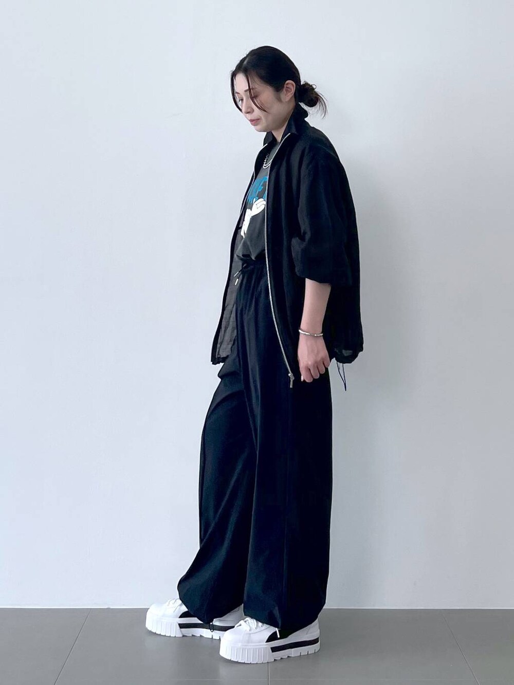 ブラック系のブルゾン、ブラック系のその他パンツ、グレー系のTシャツ/カットソーを着用したレディースの春コーディネートの2枚目の写真
