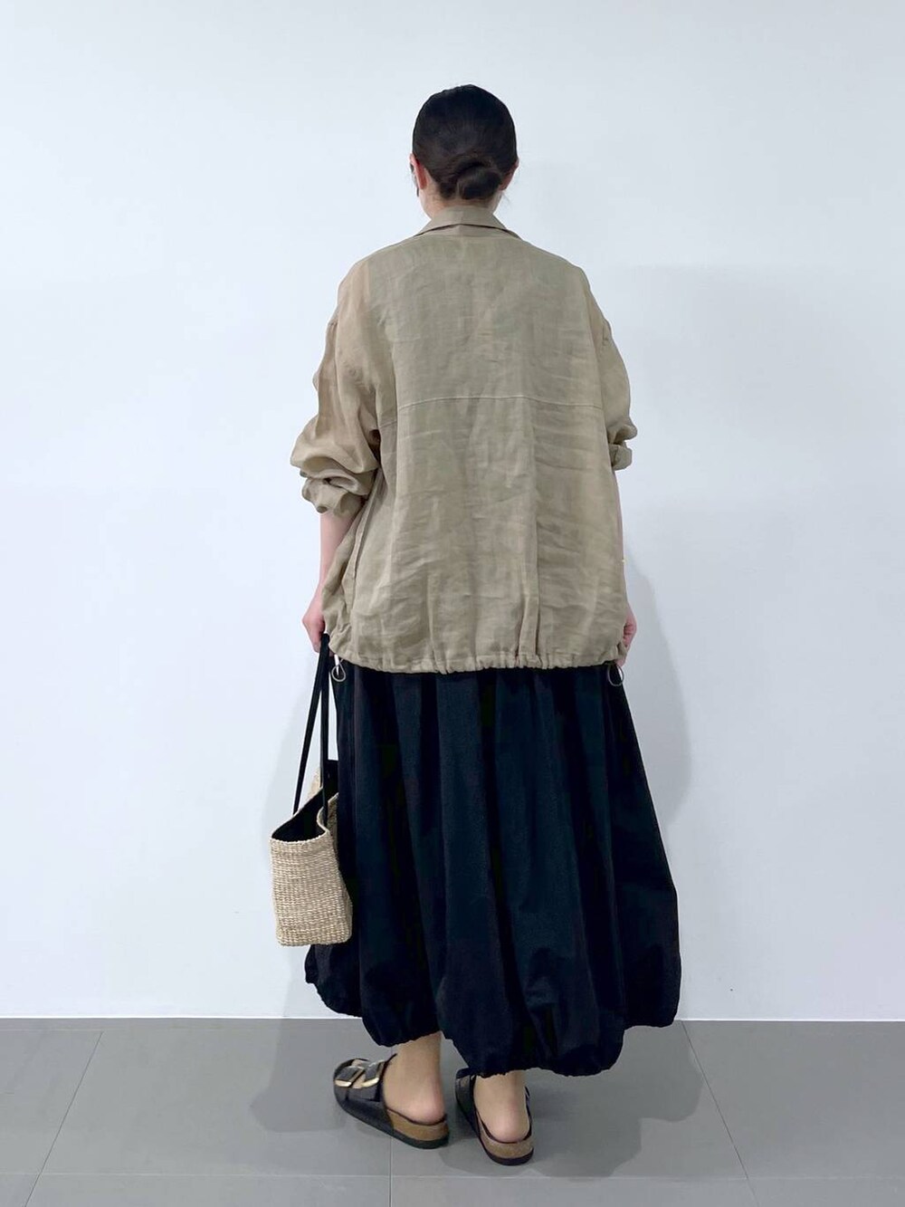 ベージュ系のブルゾン、ブラック系のサンダル、ベージュ系のかごバッグを着用したレディースの春コーディネートの3枚目の写真