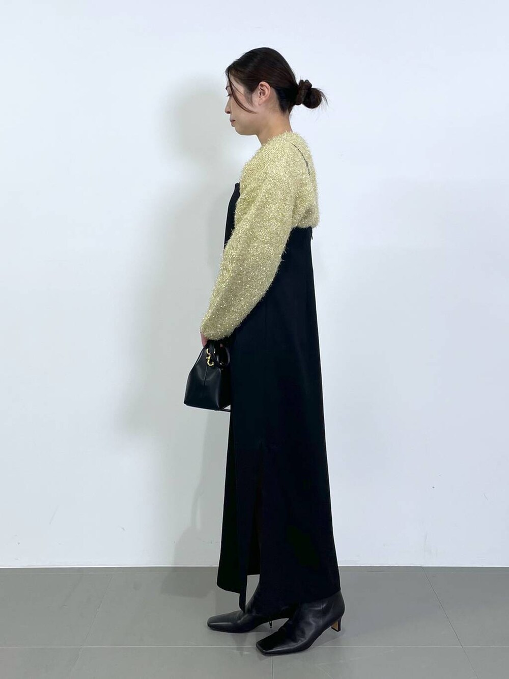 ブラウン系のニット/セーター、ブラック系のワンピースを着用したレディースの冬コーディネートの2枚目の写真