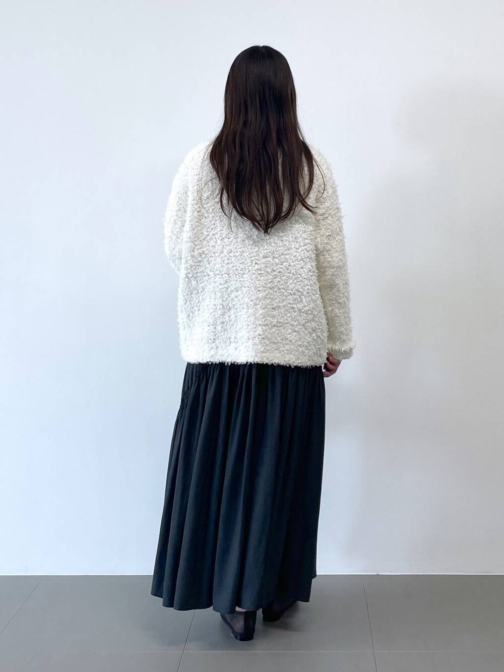 ホワイト系のショルダーバッグ、ホワイト系のカーディガン/ボレロを着用したレディースの冬コーディネートの3枚目の写真