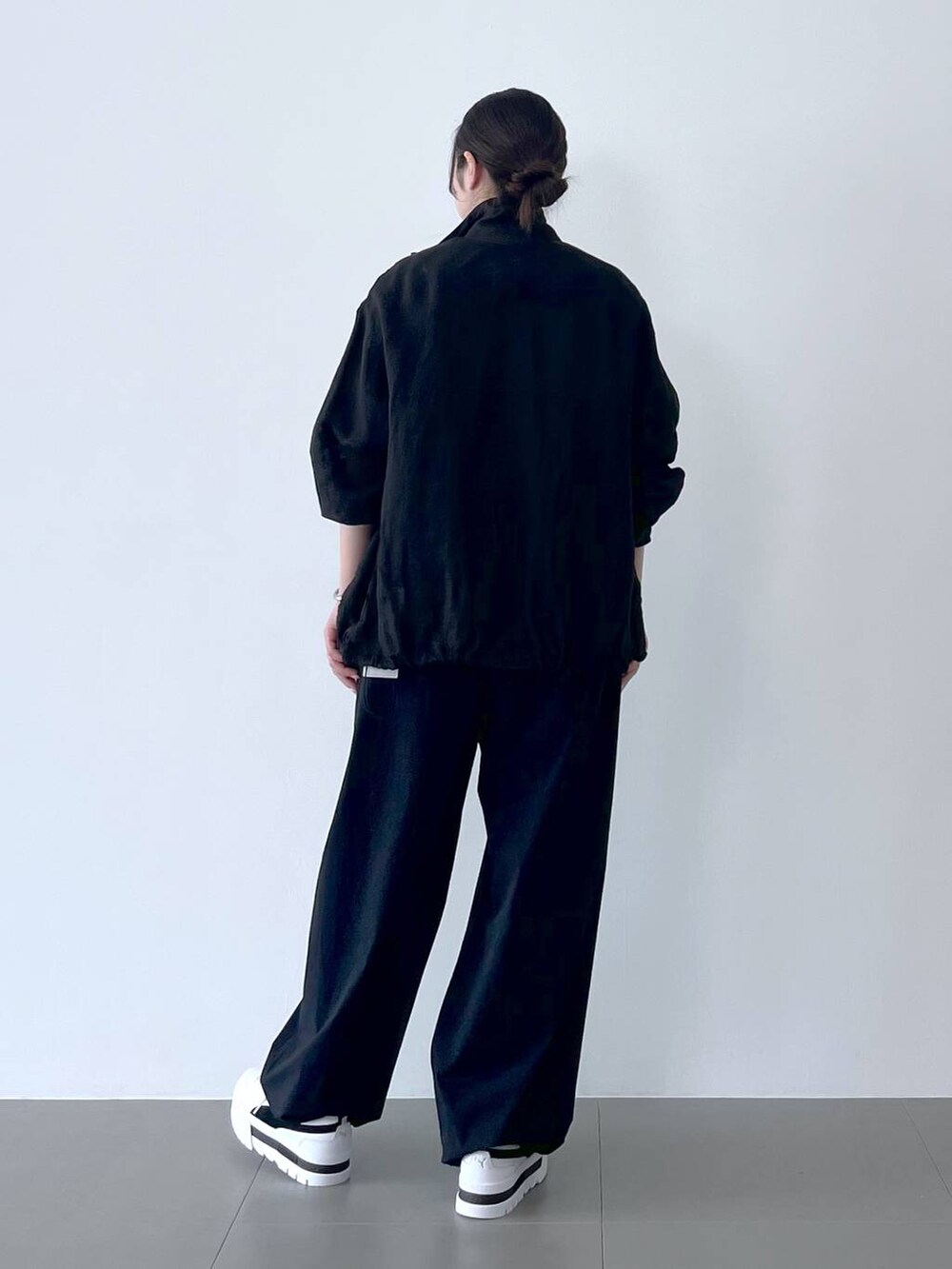 ブラック系のブルゾン、ブラック系のその他パンツ、グレー系のTシャツ/カットソーを着用したレディースの春コーディネートの3枚目の写真