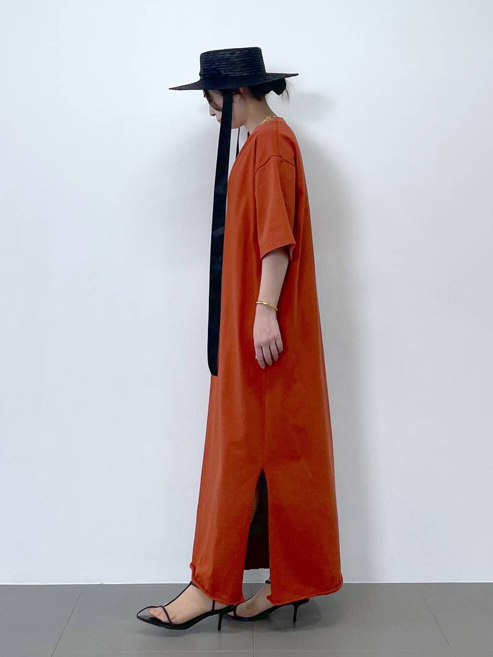 ブラック系のサンダル、オレンジ系のワンピース、ブラウン系のネックレスを着用したレディースの春コーディネートの4枚目の写真