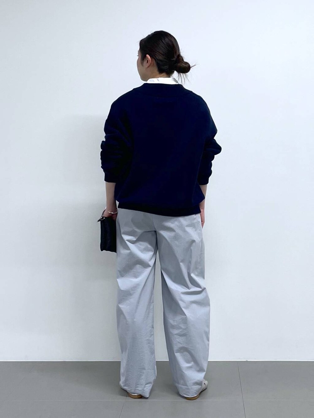 ブラック系のショルダーバッグ、ブルー系のニット/セーター、ホワイト系のシャツ/ブラウスを着用したレディースの冬コーディネートの3枚目の写真