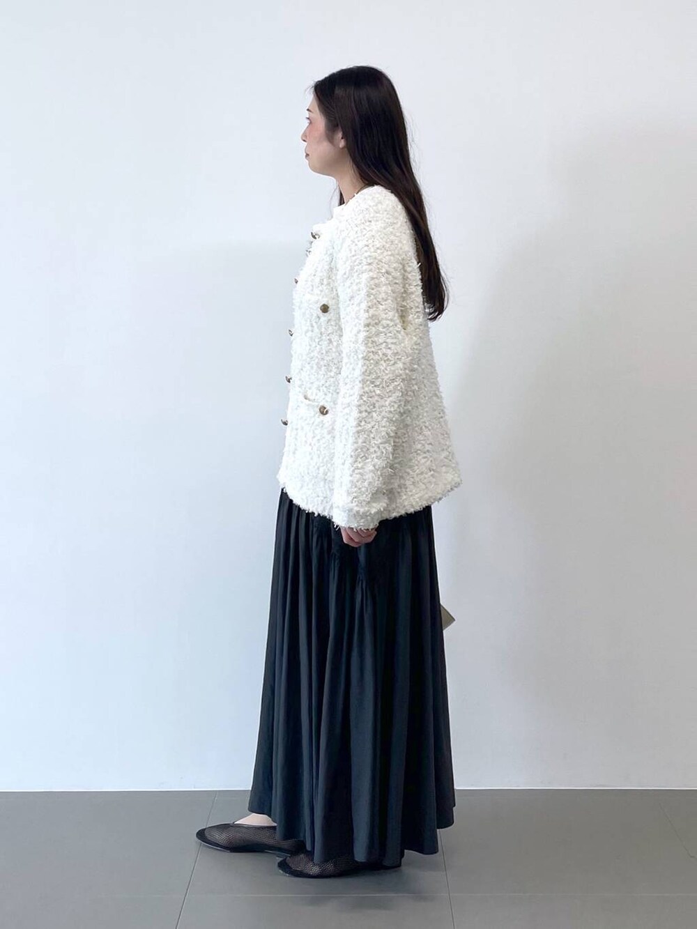 ホワイト系のショルダーバッグ、ホワイト系のカーディガン/ボレロを着用したレディースの冬コーディネートの2枚目の写真