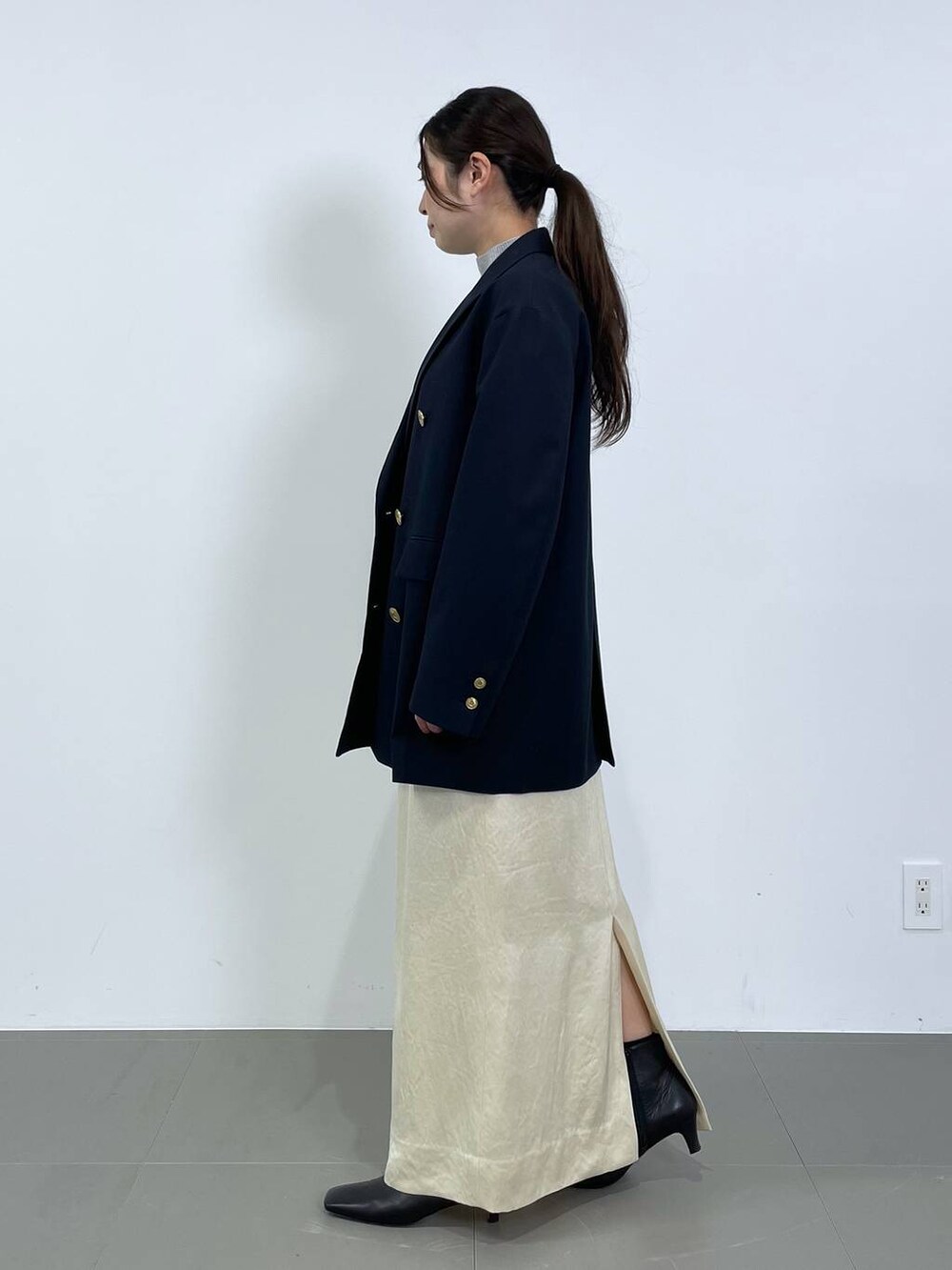 ホワイト系のスカート、ブルー系のテーラードジャケット、グレー系のニット/セーターを着用したレディースの冬コーディネートの2枚目の写真