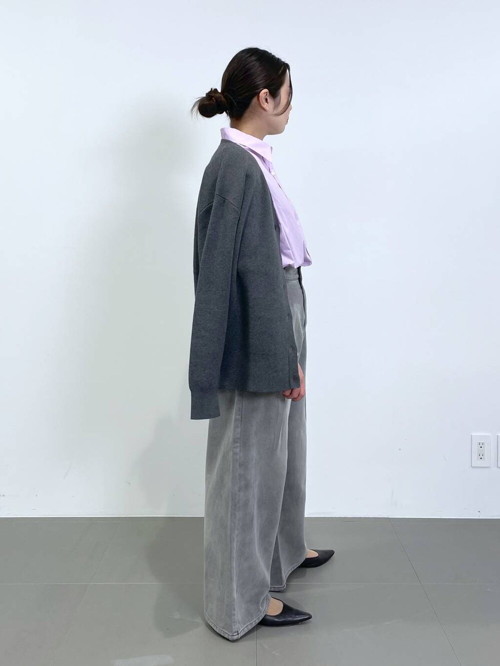 グレー系のデニムパンツ、グレー系のカーディガン/ボレロ、ピンク系のシャツ/ブラウスを着用したレディースの冬コーディネートの2枚目の写真