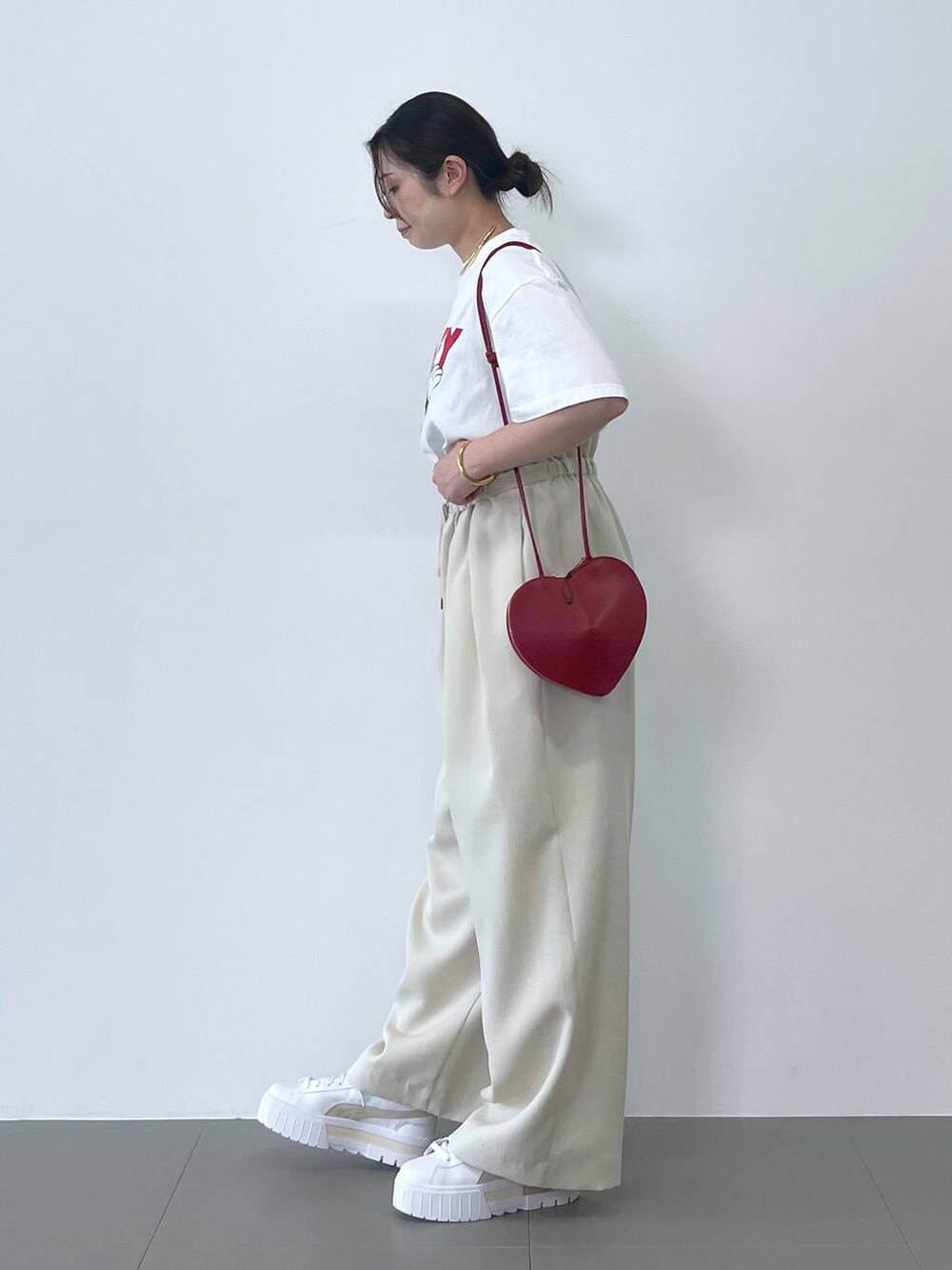 ホワイト系のTシャツ/カットソー、レッド系のショルダーバッグ、ベージュ系のその他パンツを着用したレディースの春コーディネートの2枚目の写真