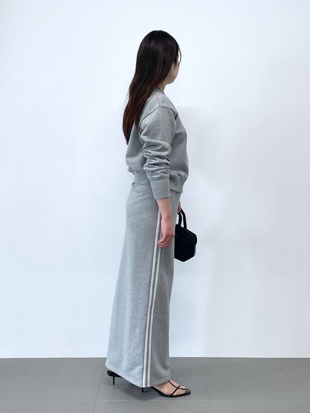 ブラック系のショルダーバッグ、グレー系のスウェット、グレー系のスカートを着用したレディースの冬コーディネートの2枚目の写真