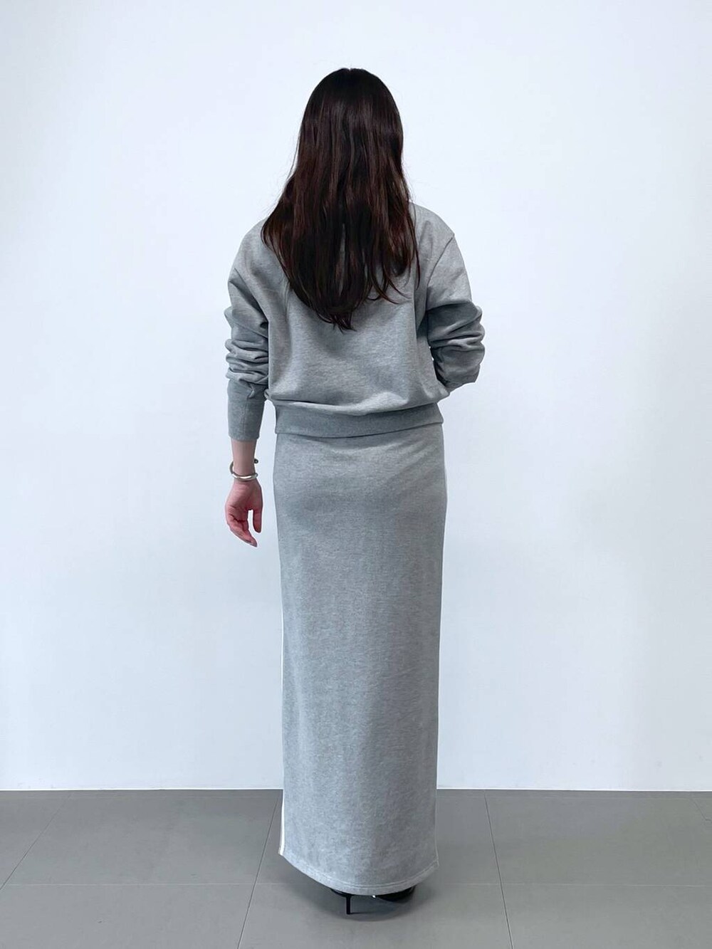 ブラック系のショルダーバッグ、グレー系のスウェット、グレー系のスカートを着用したレディースの冬コーディネートの3枚目の写真