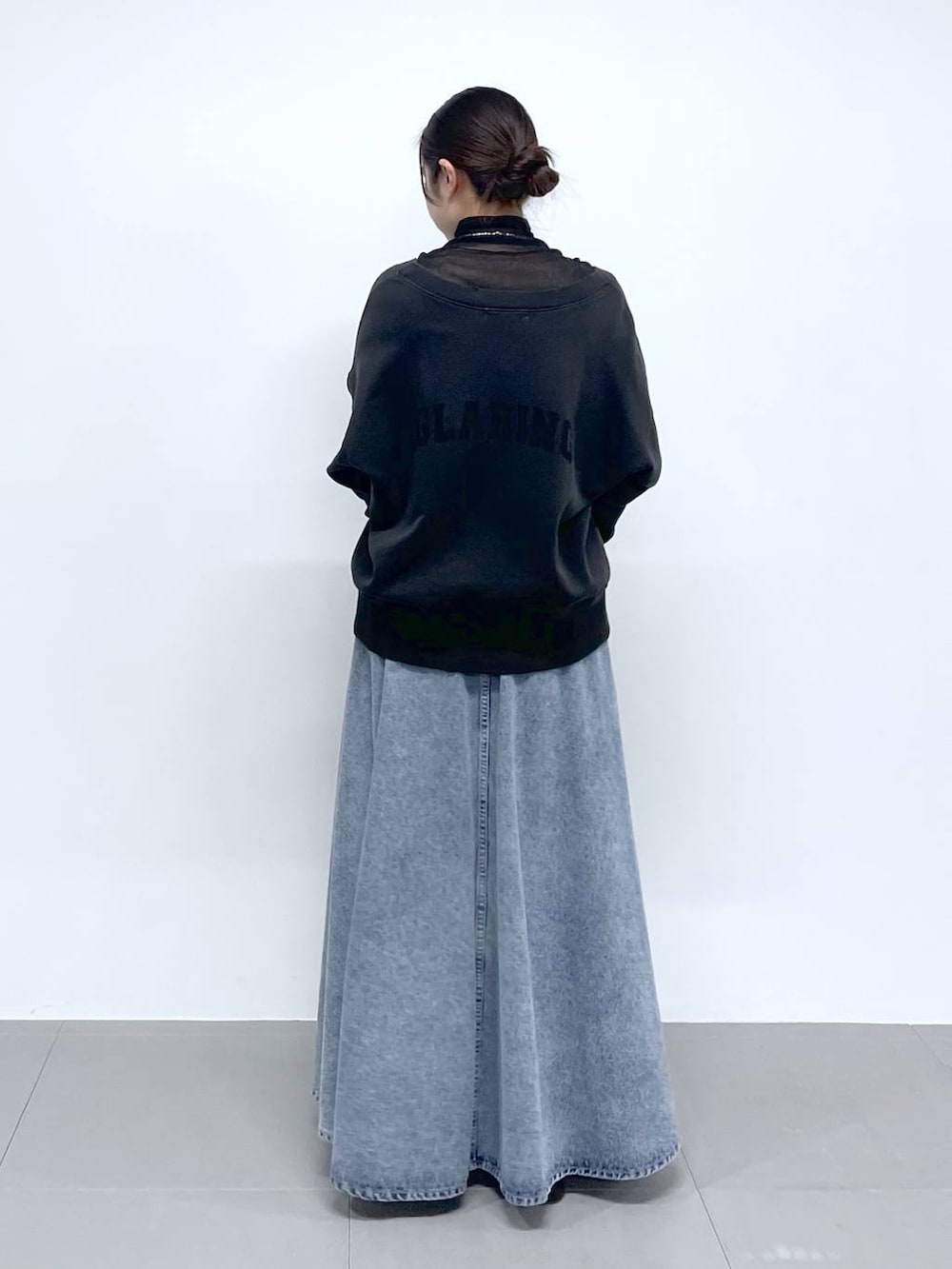 ブラック系のTシャツ/カットソー、ブルー系のデニムスカート、グレー系のカーディガン/ボレロを着用したレディースの春コーディネートの3枚目の写真