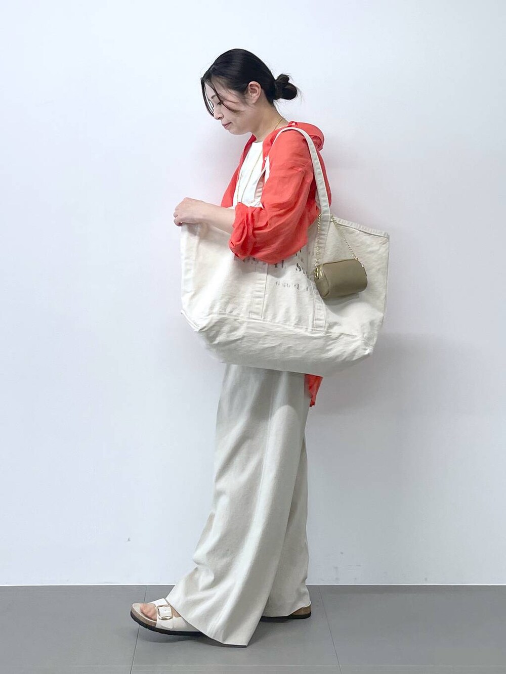 ホワイト系のサンダル、オレンジ系のシャツ/ブラウス、ベージュ系のその他パンツを着用したレディースの春コーディネートの2枚目の写真