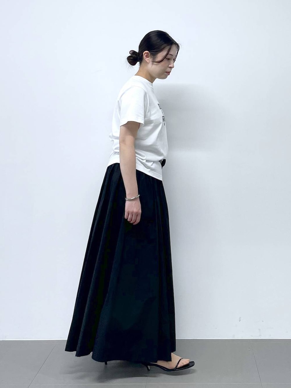 ホワイト系のTシャツ/カットソー、ブラック系のボディバッグ/ウエストポーチ、ブラック系のスカートを着用したレディースの春コーディネートの2枚目の写真