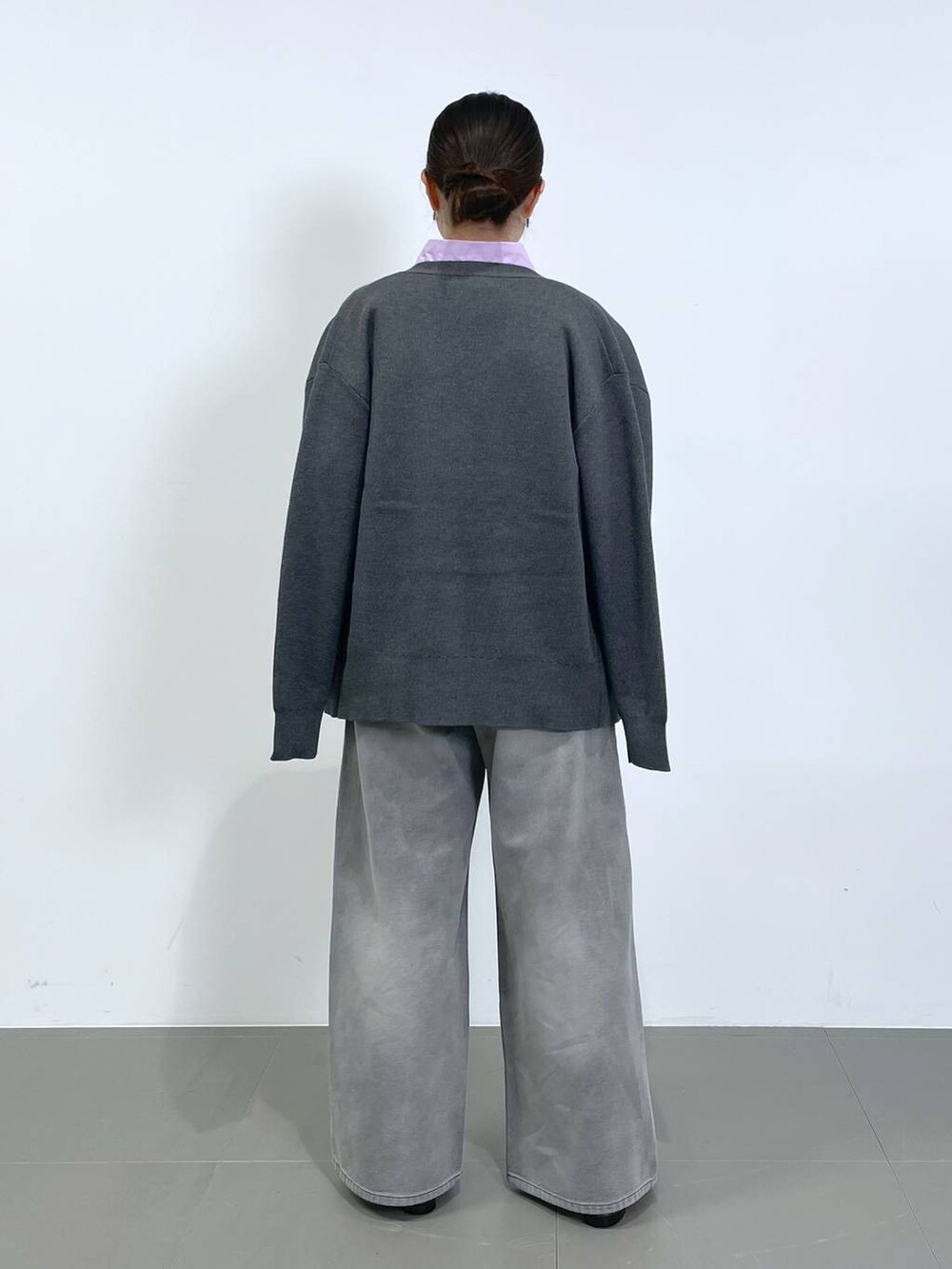 グレー系のデニムパンツ、グレー系のカーディガン/ボレロ、ピンク系のシャツ/ブラウスを着用したレディースの冬コーディネートの3枚目の写真