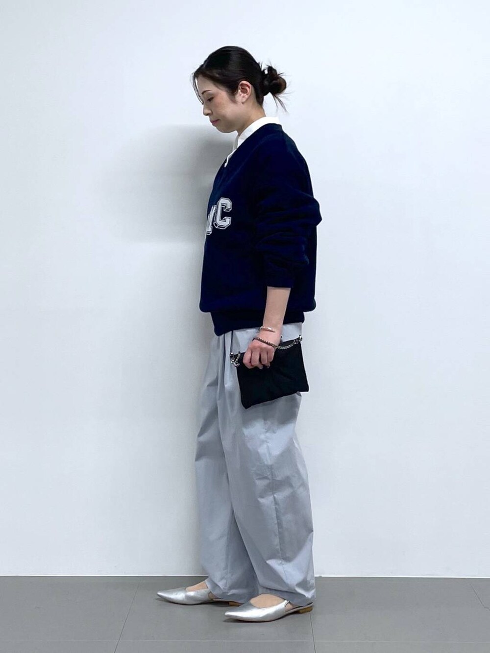 ブラック系のショルダーバッグ、ブルー系のニット/セーター、ホワイト系のシャツ/ブラウスを着用したレディースの冬コーディネートの2枚目の写真