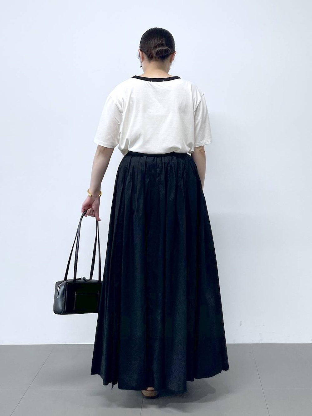 ブラック系のサンダル、ホワイト系のTシャツ/カットソーを着用したレディースの春コーディネートの3枚目の写真