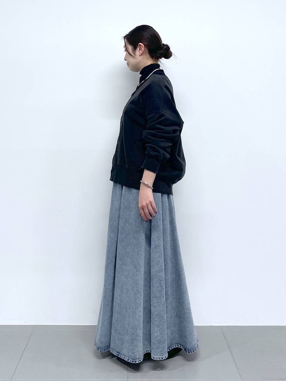 ブラック系のTシャツ/カットソー、ブルー系のデニムスカート、グレー系のカーディガン/ボレロを着用したレディースの春コーディネートの2枚目の写真