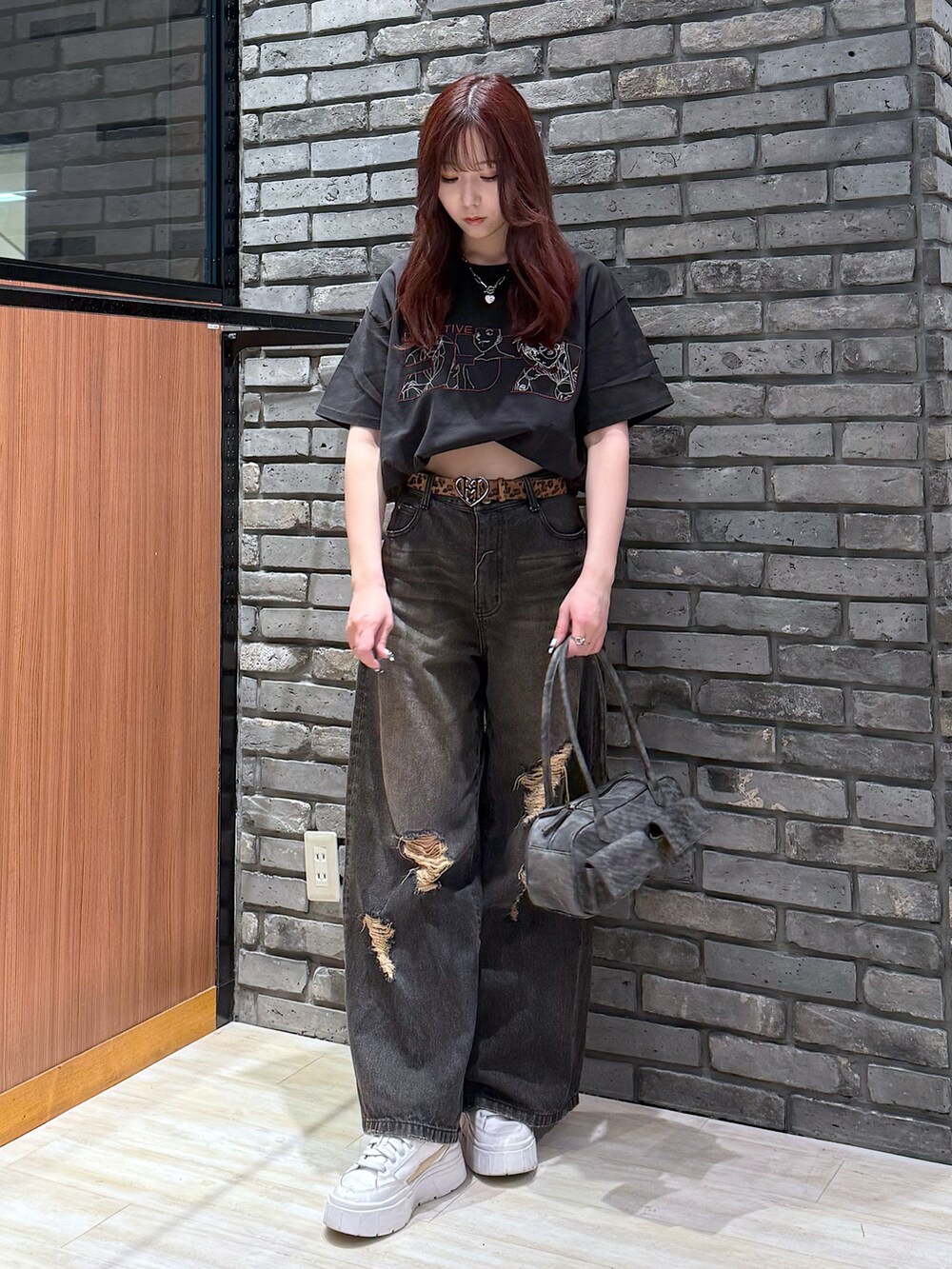 ブラック系のデニムパンツ、ブラック系のボストンバッグを着用したレディースの春コーディネートの2枚目の写真