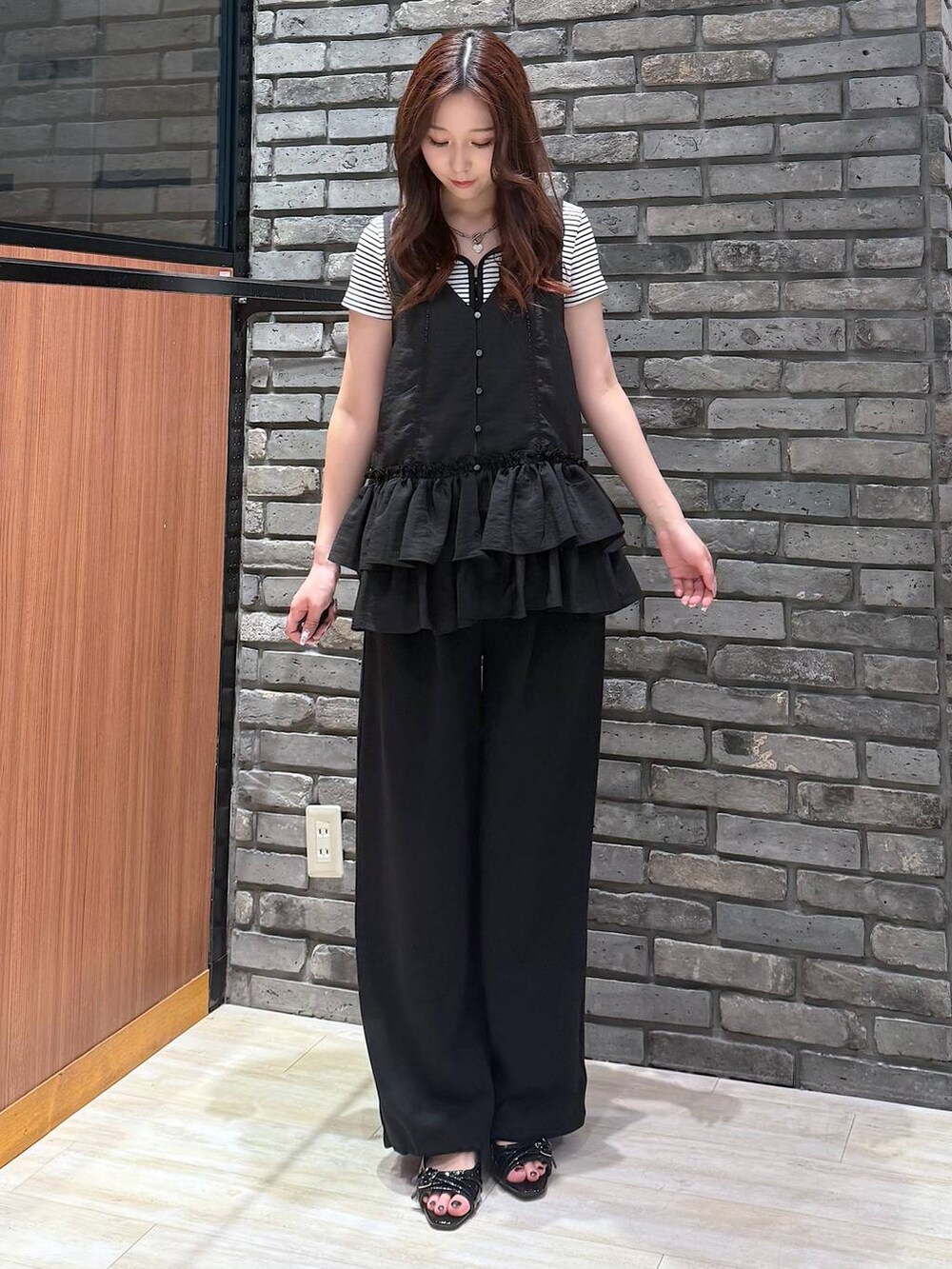 ブラック系のサンダル、ホワイト系のTシャツ/カットソー、ブラック系のスウェットパンツを着用したレディースの夏コーディネートの5枚目の写真