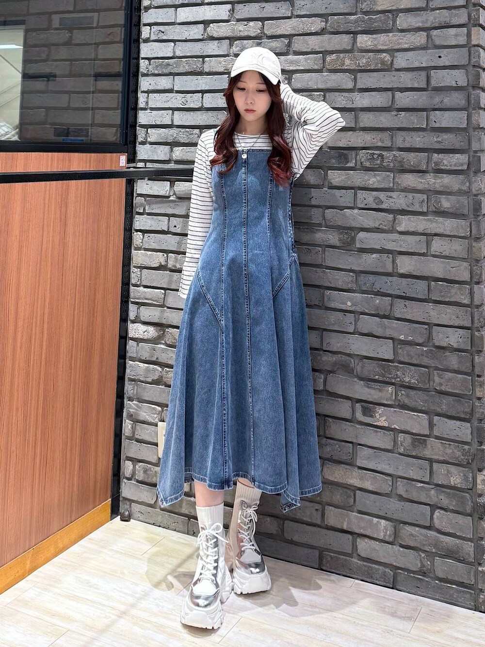 ホワイト系のブーツ、ホワイト系のTシャツ/カットソー、ブルー系のワンピースを着用したレディースの冬コーディネートの2枚目の写真