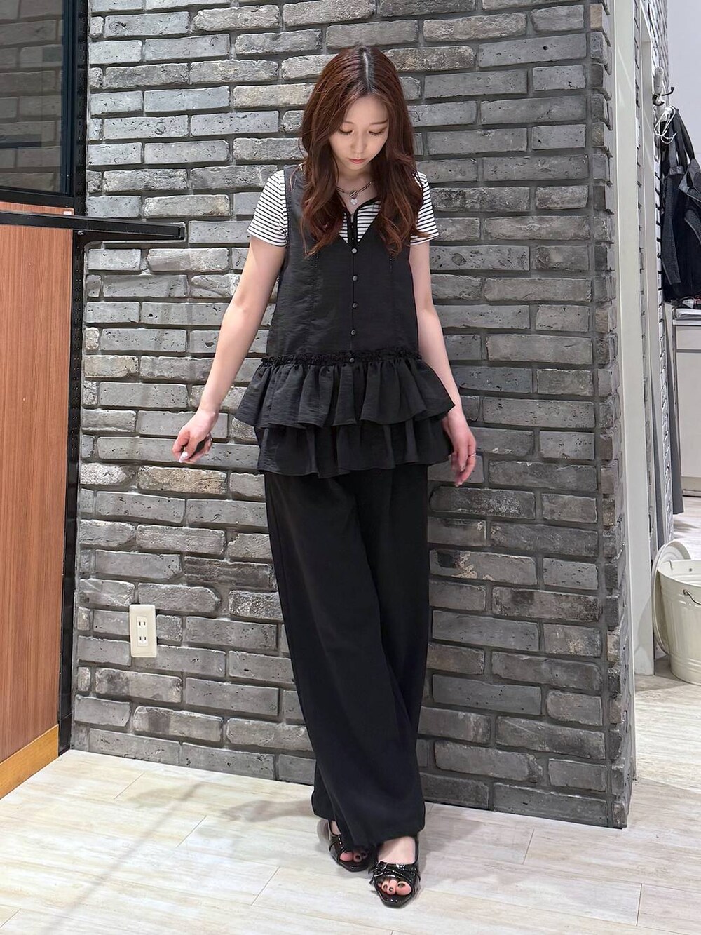 ブラック系のサンダル、ホワイト系のTシャツ/カットソー、ブラック系のスウェットパンツを着用したレディースの夏コーディネートの2枚目の写真