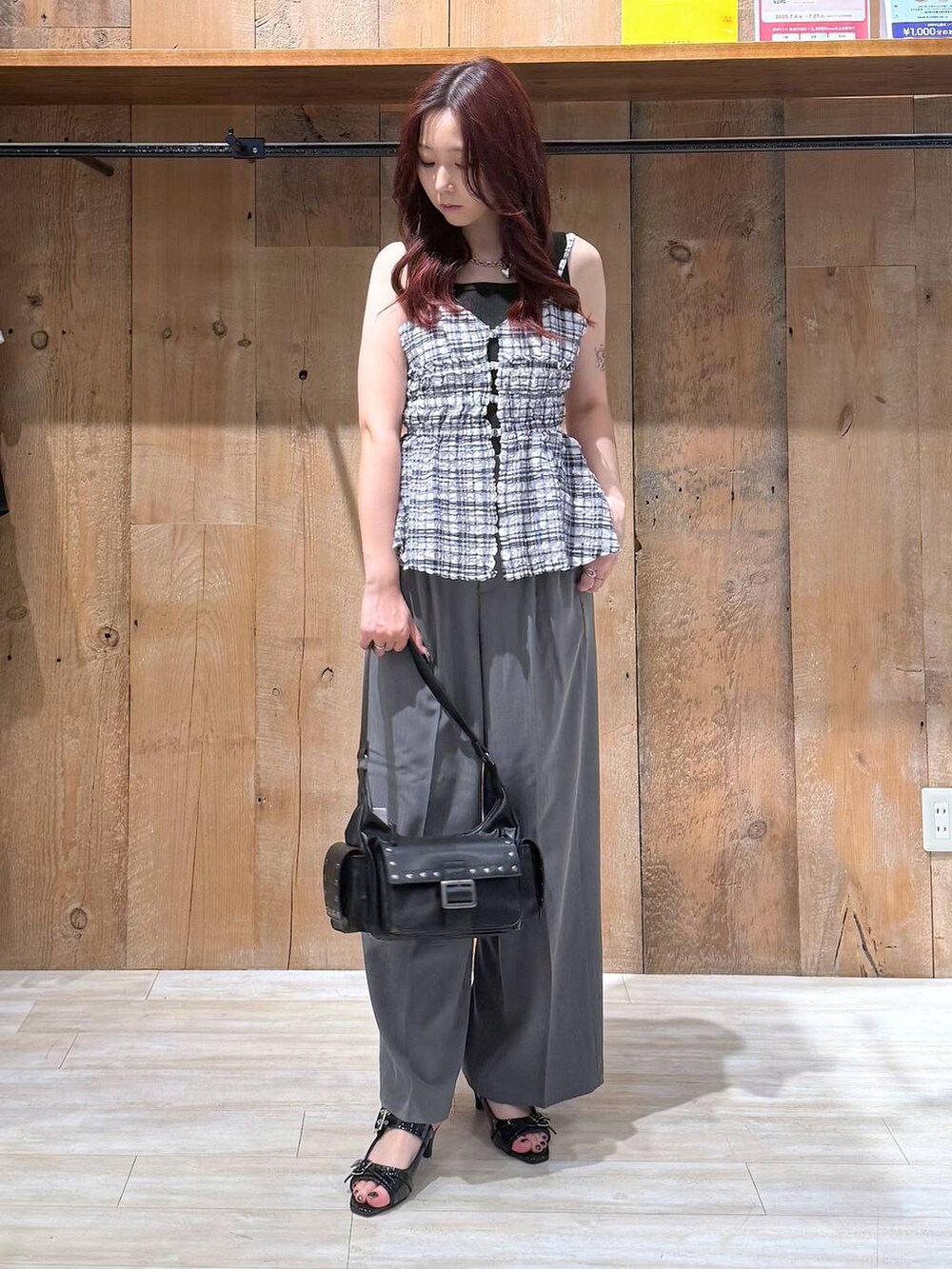 ブラック系のサンダル、グレー系のスラックス、ブラック系のショルダーバッグを着用したレディースの夏コーディネートの2枚目の写真